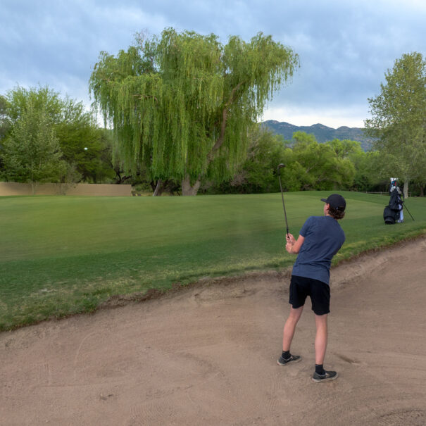 a man chipping out of a bunker on hole 5 of forty niner country club